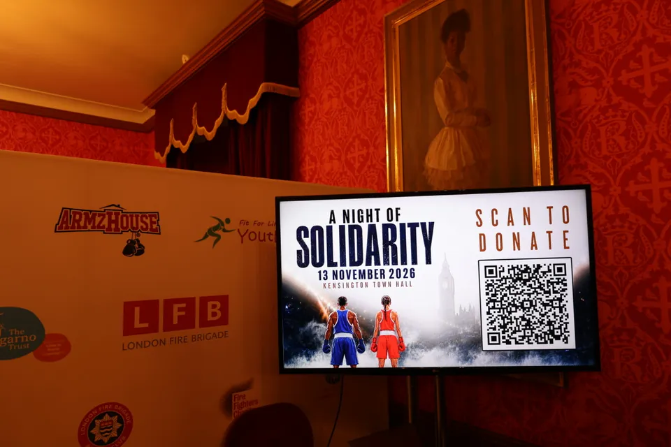A Scan to Donate screen beside the event sponsor board