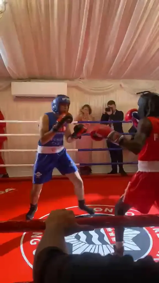 Video of a boxer in a red FIRE vest trading punches with a boxer in blue in the ring