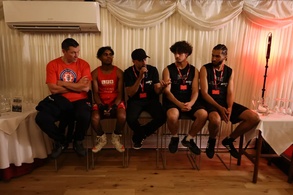 Boxers in London Fire Brigade kit sit together for a panel as one speaks