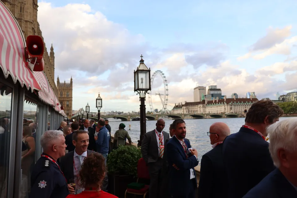 Guests talk on the River Terrace in the evening light, with the London Eye behind