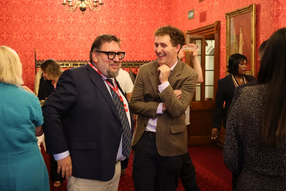 Two guests share a laugh in a red state room