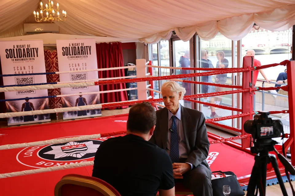 A guest is interviewed ringside in front of A Night of Solidarity banners